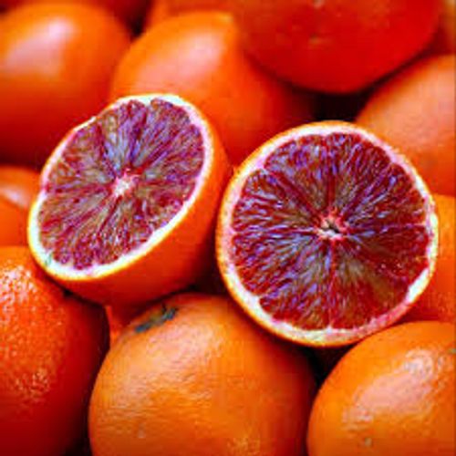 Delade blodapesliner med rött fruktkött och hela orange blodapelsiner